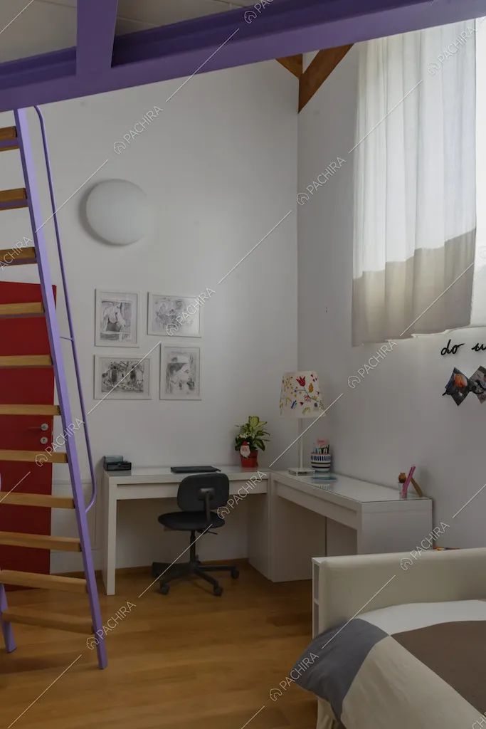Camera da letto con infissi viola del soppalco, scrivania bianca e pavimento in parquet