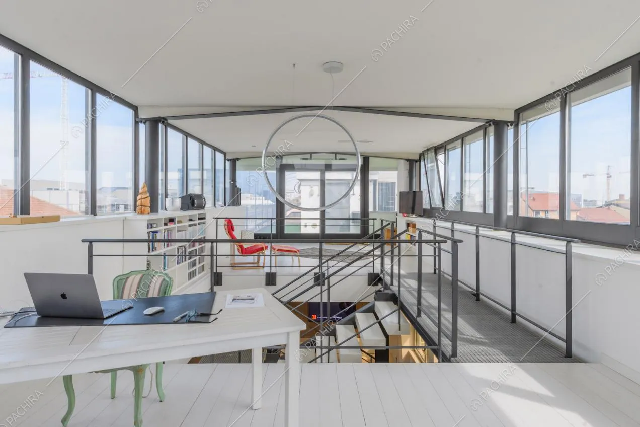 Studio al piano superiore della location con vetrate su ogni parete e pavimento bianco