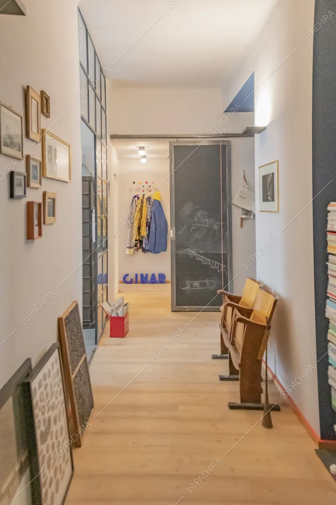 Sedie da cinema vintage di legno e piccoli quadri appesi alla parete