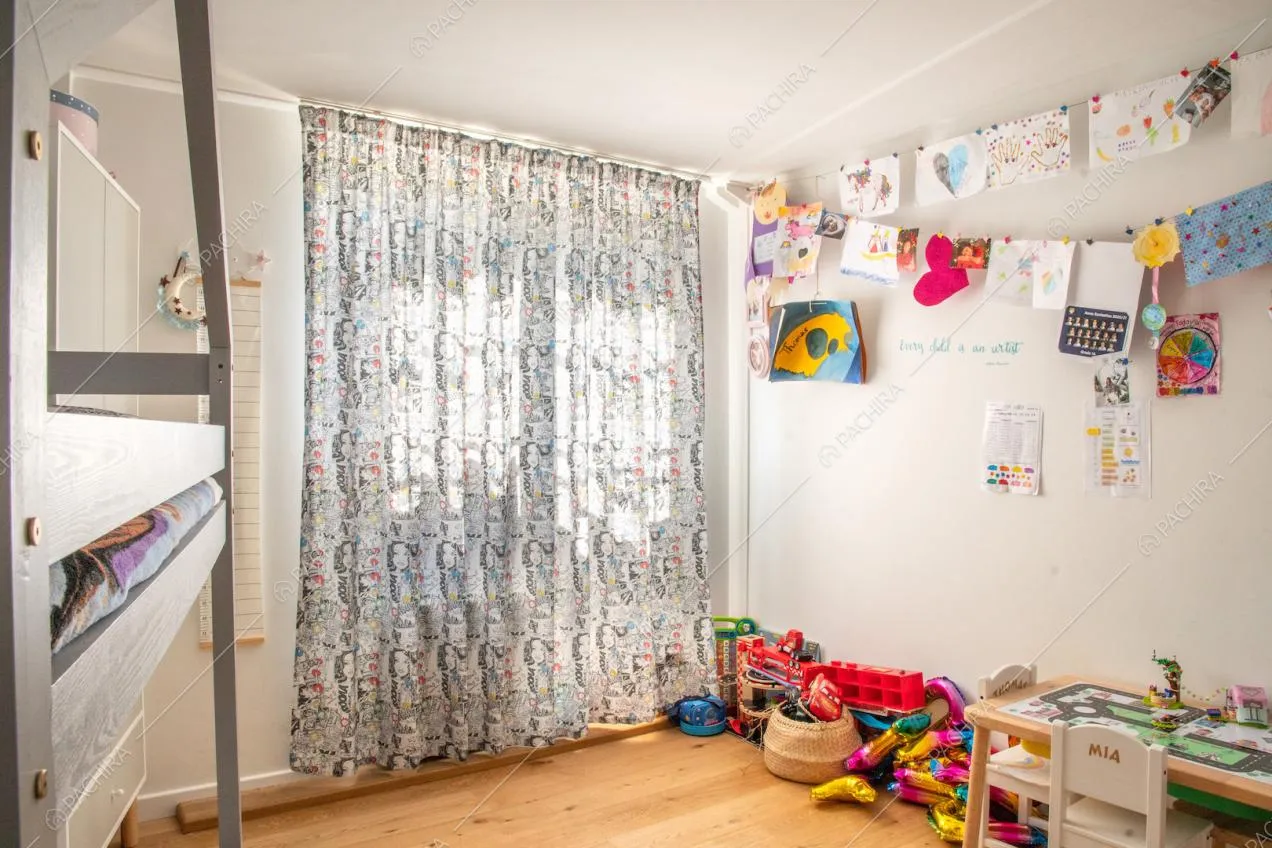 Luminosa camera da letto da bambini con letto a castello, pareti bianche e pavimento in parquet