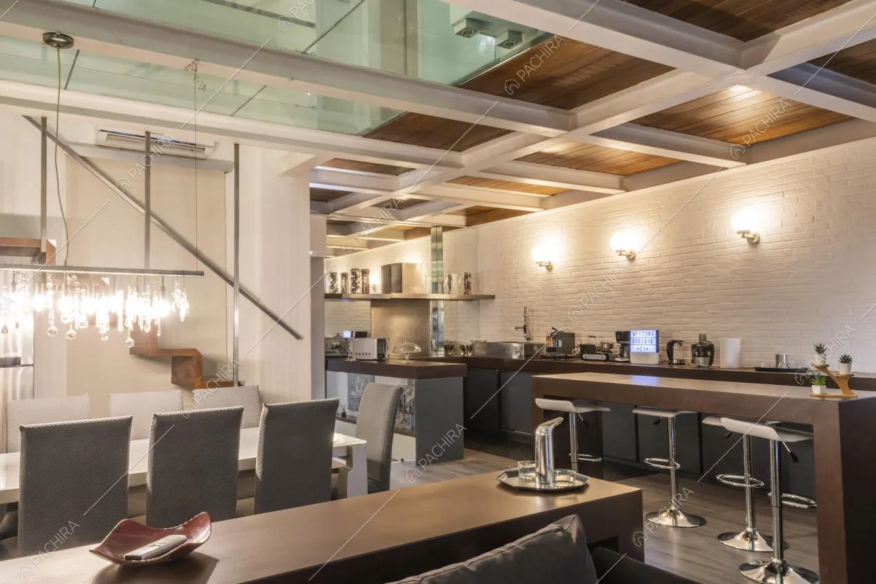 Spaziosa cucina a vista lungo la parete in mattoni bianchi