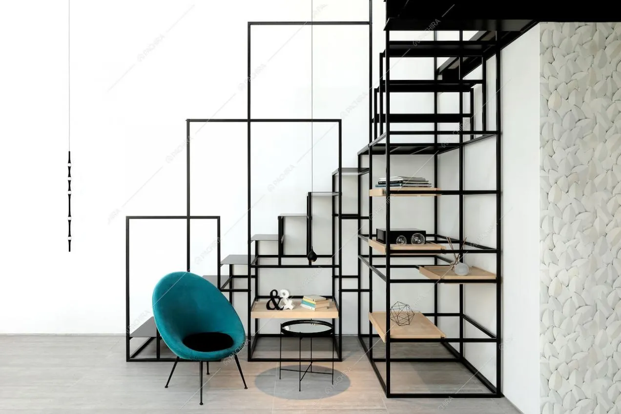 Particolari scale nere in metallo che poggiano su una libreria e poltrona di design