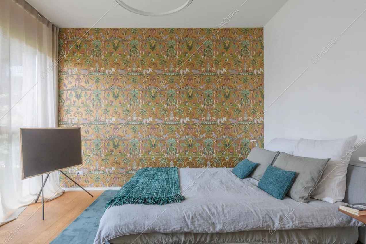 Letto matrimoniale nella luminosa camera con carta da parati a fantasia tropicale