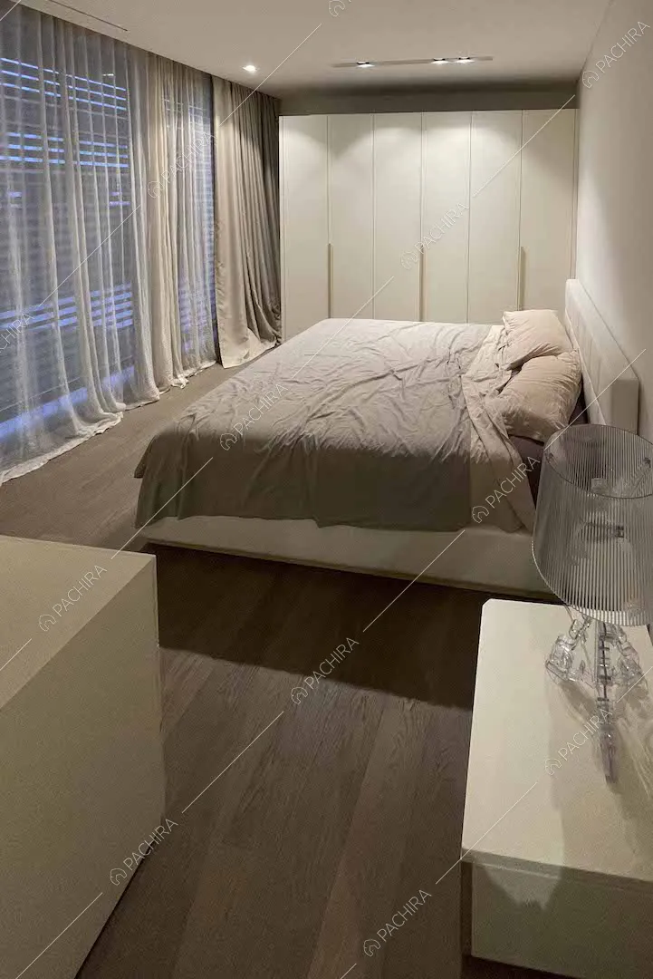 Camera da letto matrimoniale con ampia vetrata e armadio bianco