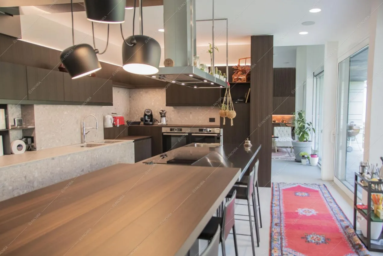 Isola della cucina con sgabelli, fornelli a induzione e faretti neri