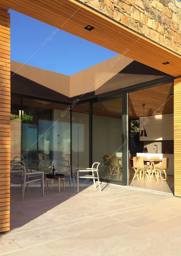 Veranda con pavimentazione in lastre di pietra bianche, arco in stile moderno e vista sulla cucina