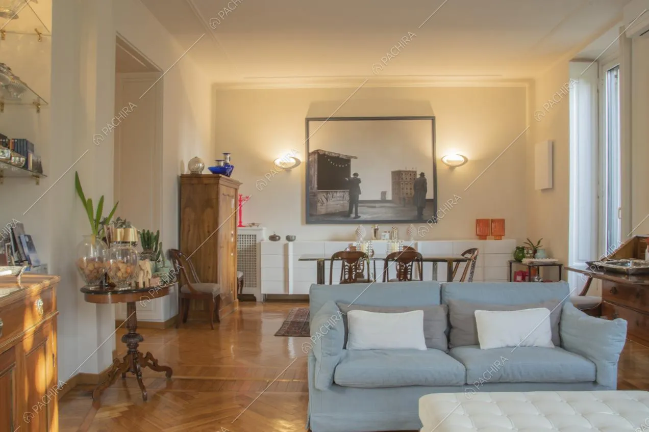 Antico tavolino in legno scuro con piante in vaso e quadro appeso alla parete