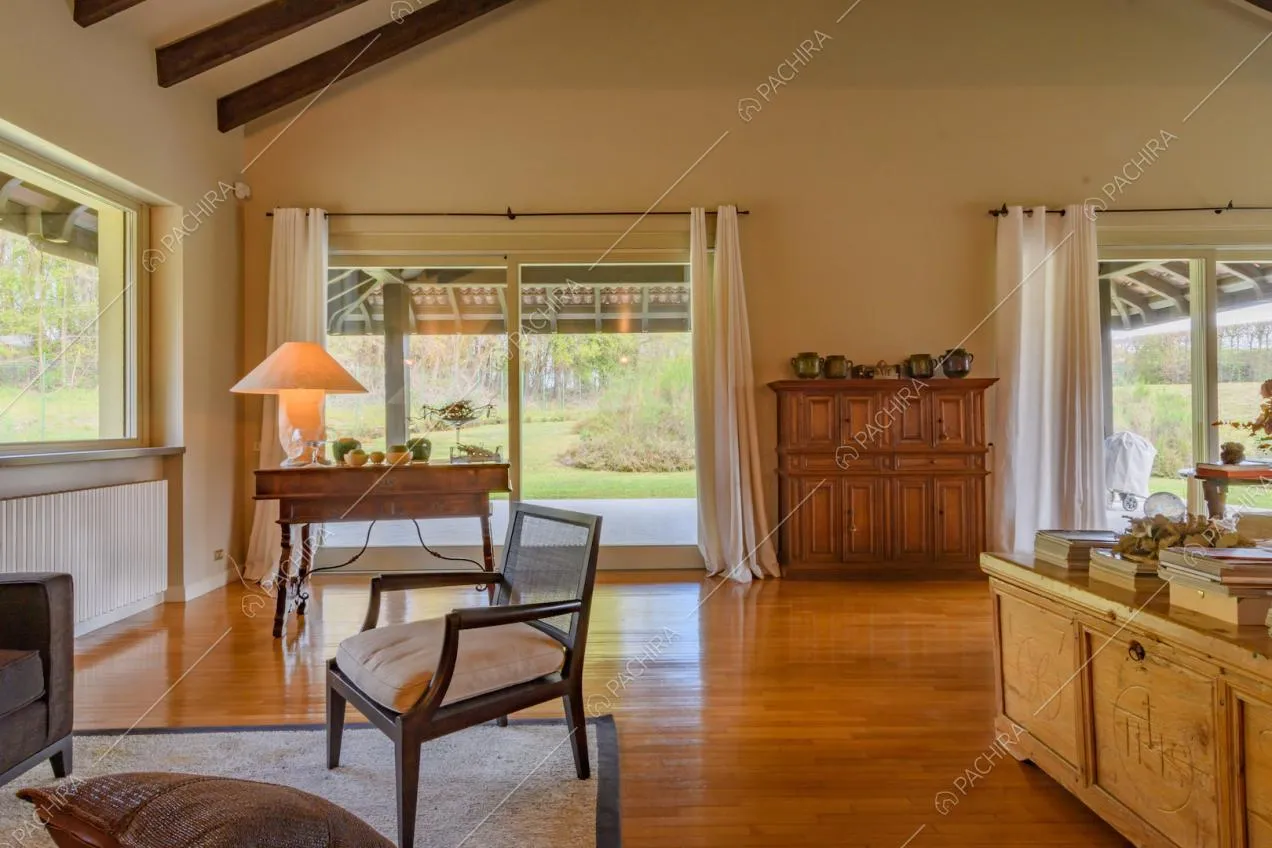 Pavimento in parquet nella zona living con porte-finestre scorrevoli e travi a vista