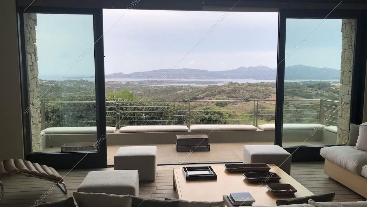 Terrazza con vista mare, pouf bianchi e tavolino quadrato