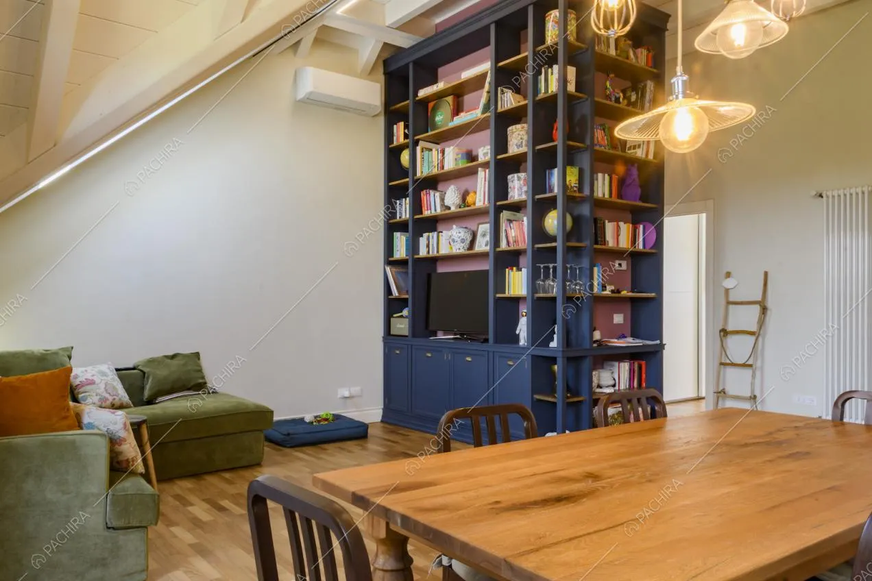 Libreria blu con libri e oggetti al centro della zona giorno