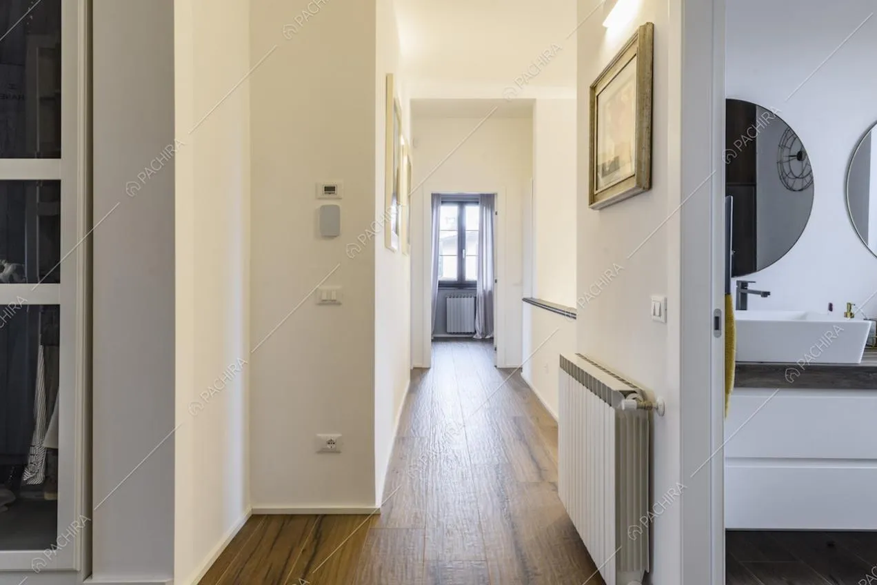 Corridoio con pavimento in parquet e pareti bianche