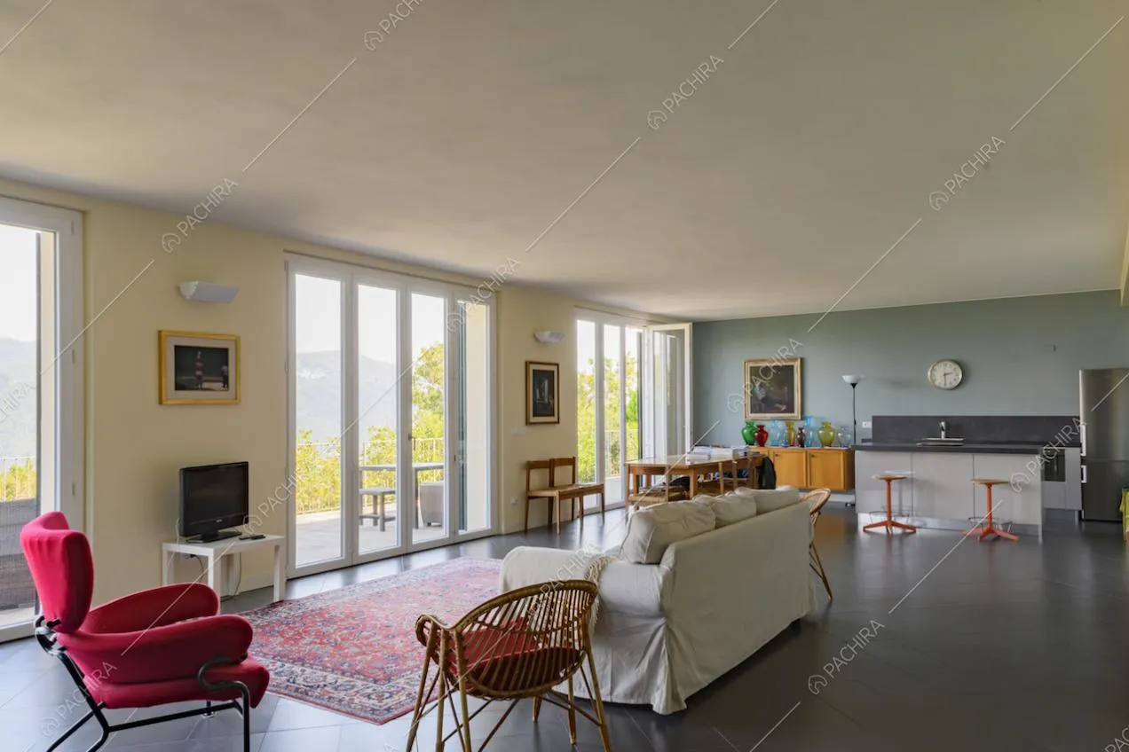 Salotto con cucina a vista e ampie porte-finestre