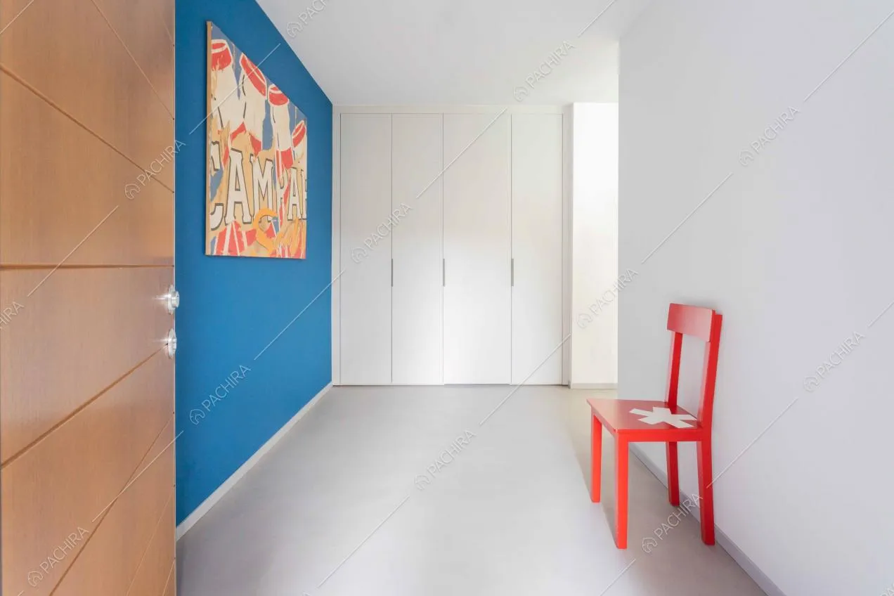 Ingresso della location con armadi bianchi a muro e parete blu