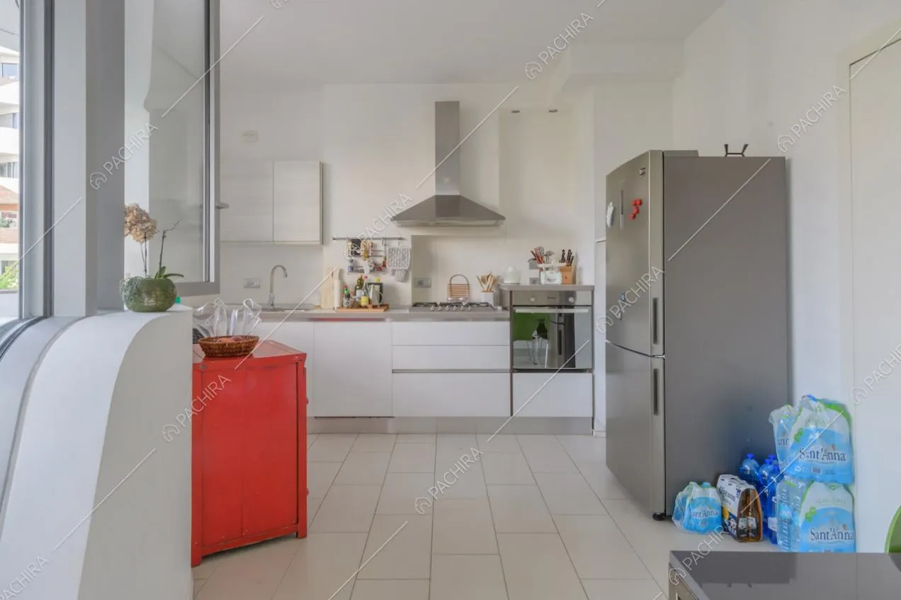 Cucina a parete bianca con fornelli a gas e porte-finestre