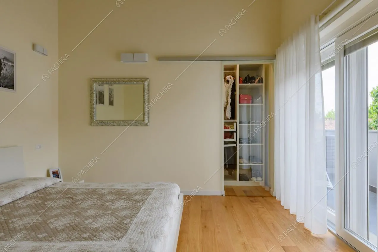 Camera da letto matrimoniale con pavimento in parquet e cabina armadio
