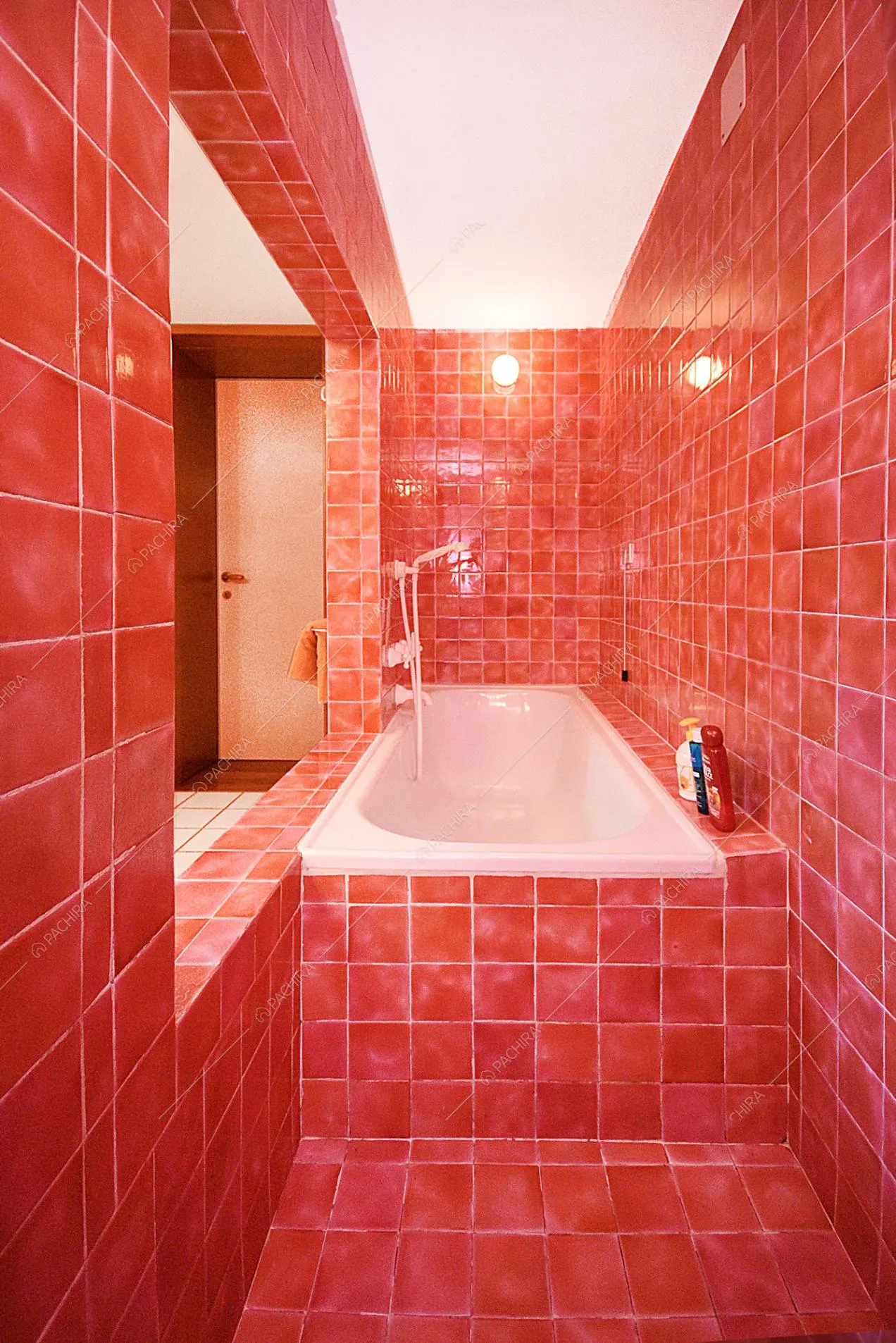 Vasca da bagno tra muri rivestiti con piastrelle rosse