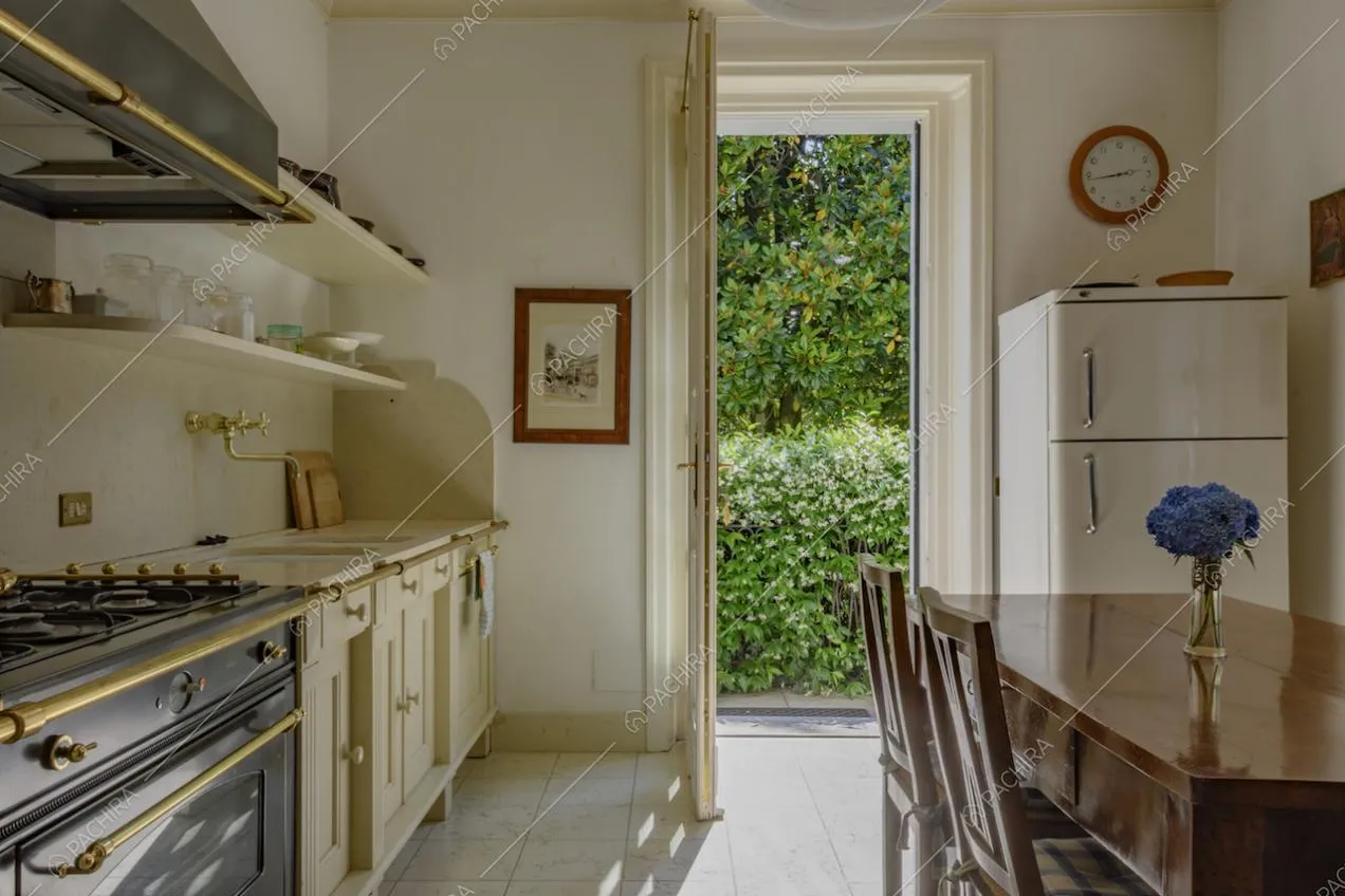 Cucina a parete con mobili bianchi e neri e frigorifero