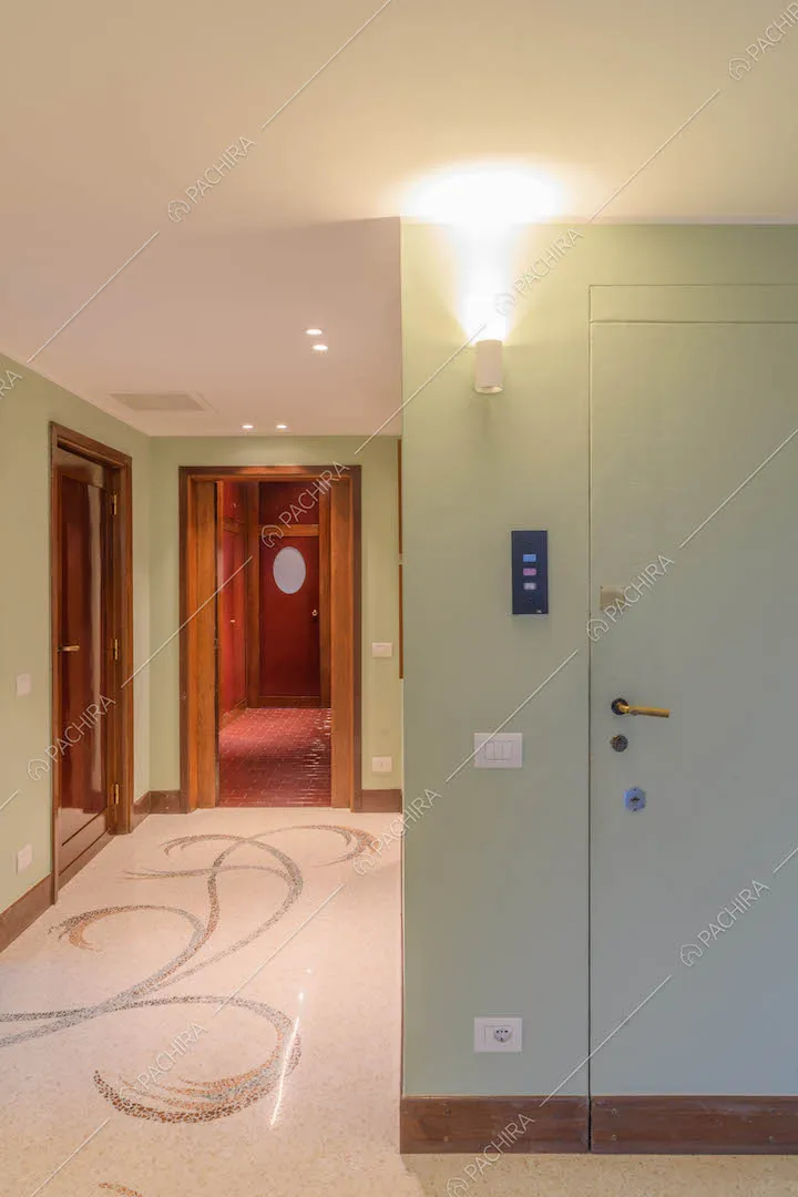 Ingresso con pareti verde chiaro e pavimento in marmo