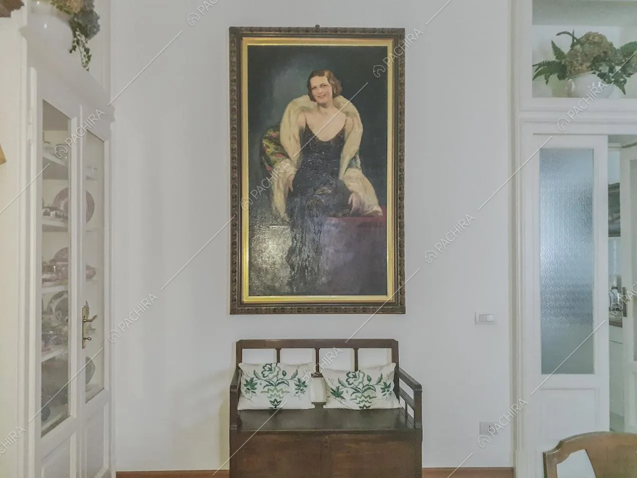 Dipinto con ritratto d'epoca appeso alla parete e panca d'antiquariato