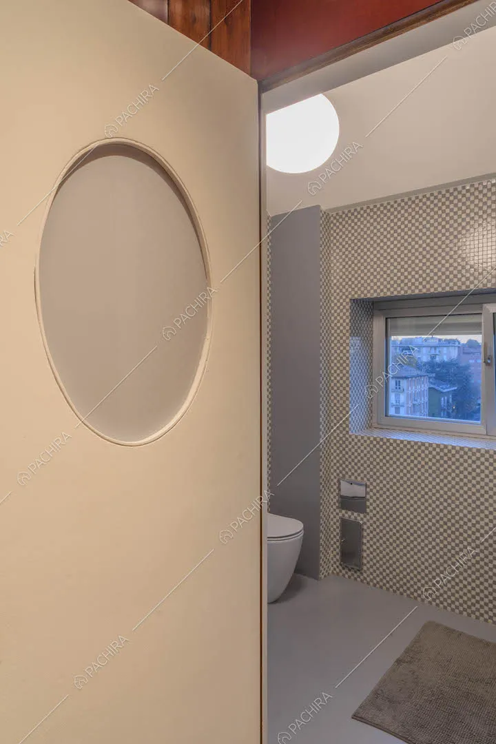 Bagno con parete in piccole piastrelle grigie e bianche