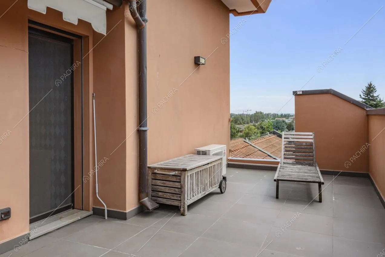 Angolo di terrazzo con sedia a sdraio e mobile in legno grezzo