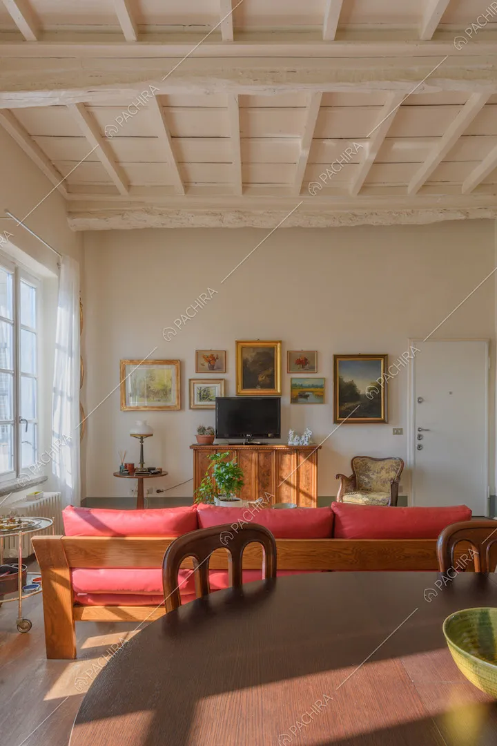 Luminosa sala con soffitto bianco a cassettoni, pavimento in parquet e tavolo da pranzo