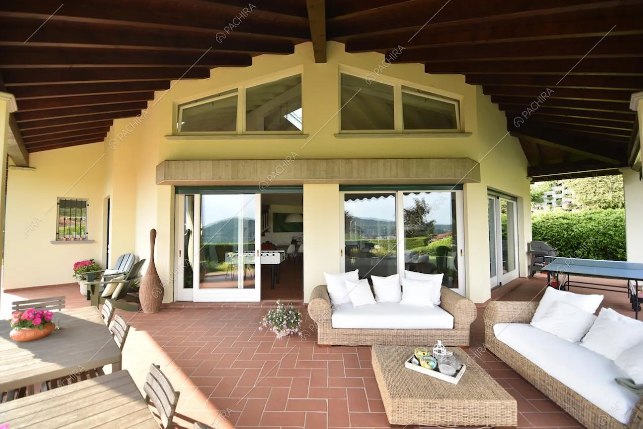 Divani in vimini con cuscini bianchi e tavolini nel patio