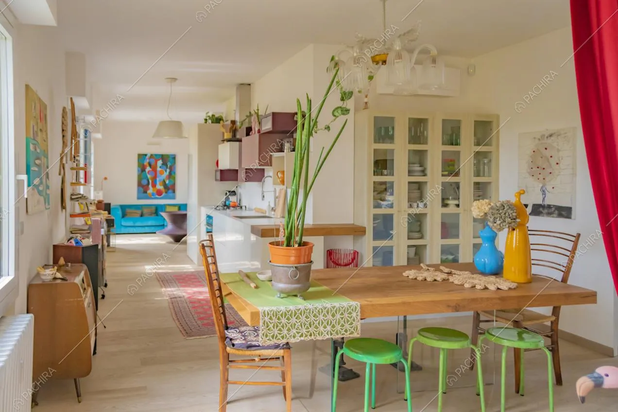 La zona living con parquet chiaro e arredi colorati