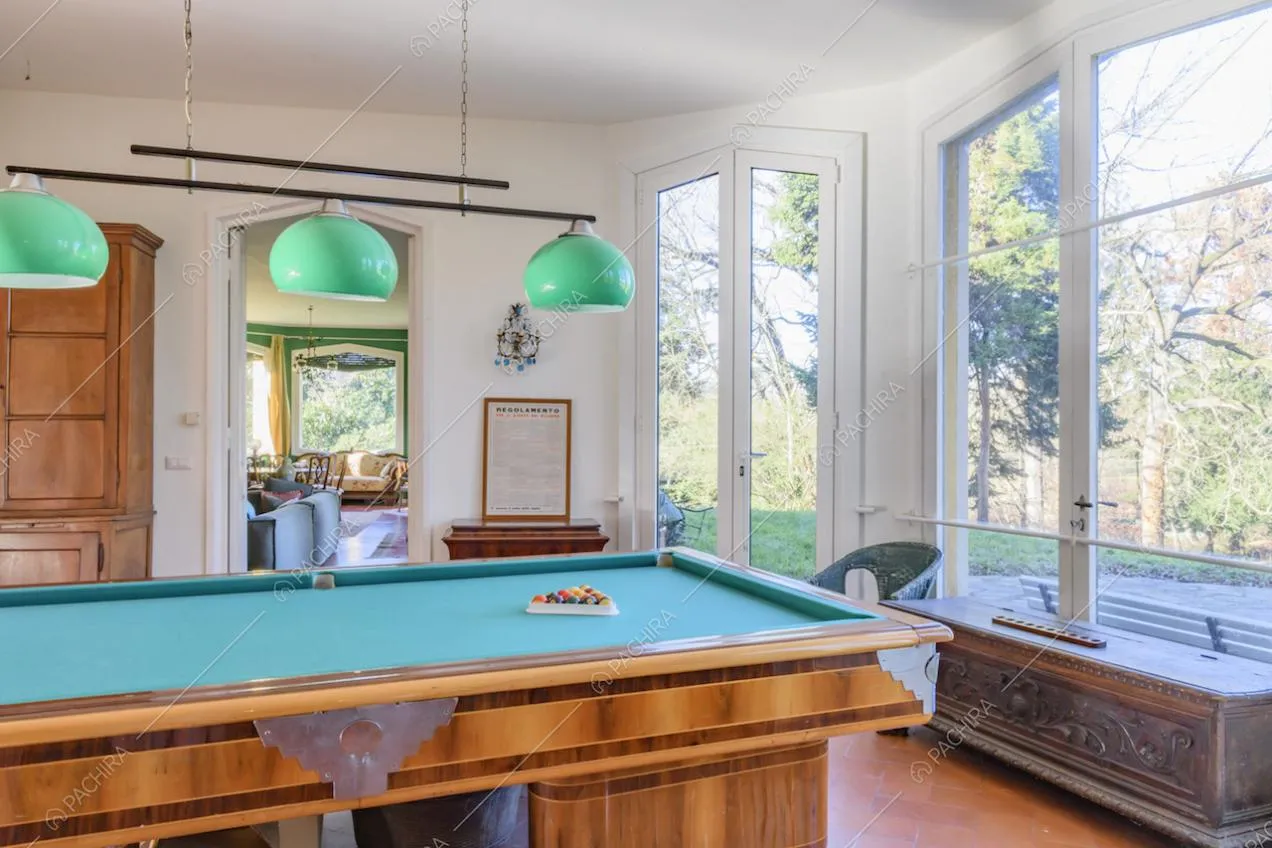 Sala biliardo posta al pianterreno con porte-finestre che portano al giardino privato