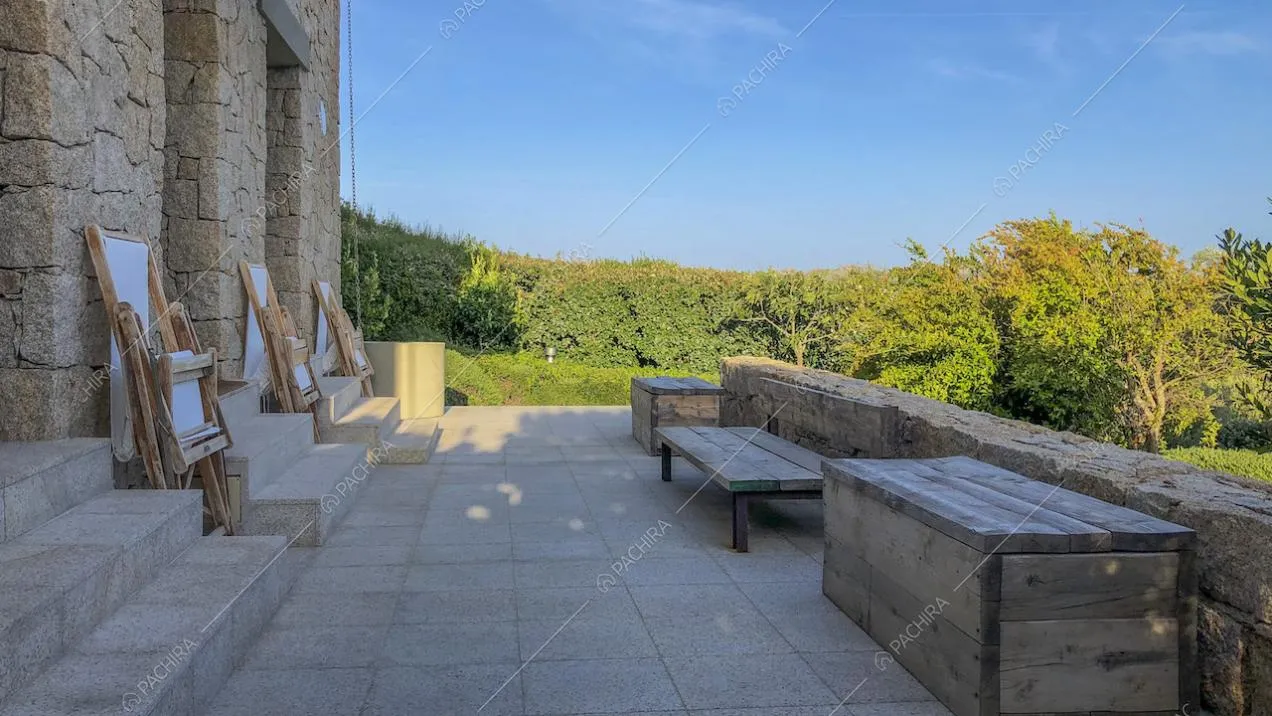 Patio con arredi in legno grezzo affacciato sul giardino