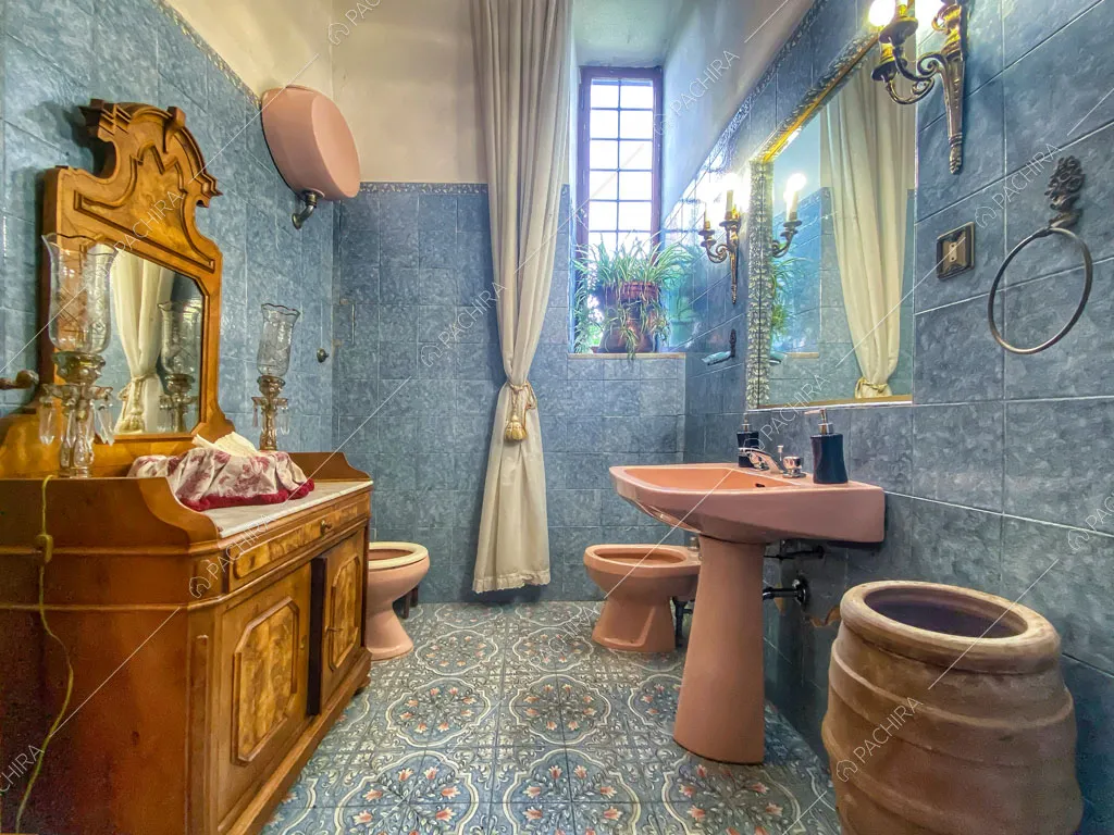 Luminoso bagno con piastrelle su pavimento e pareti e sanitari rosa