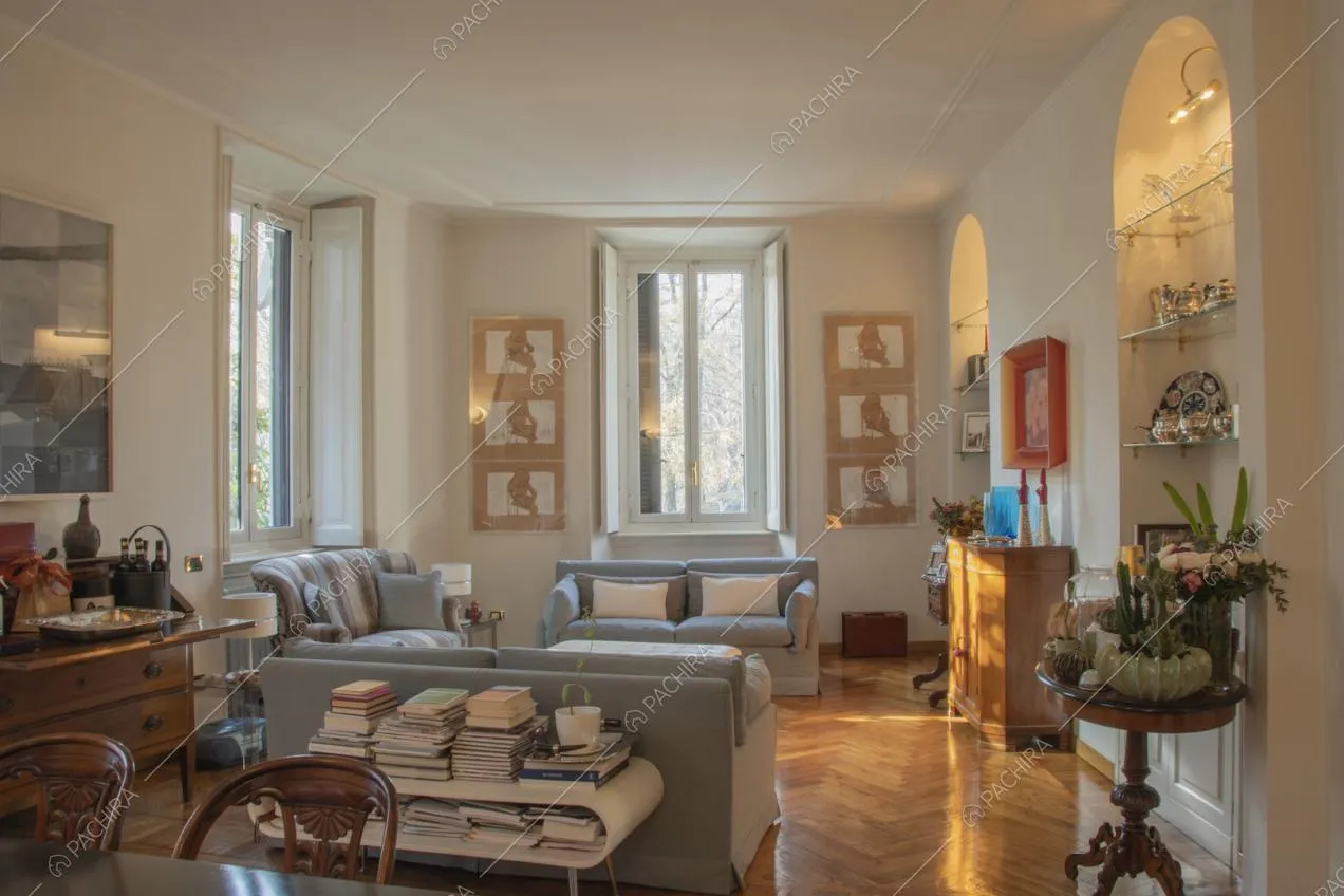 Soggiorno con mobili antichi in legno scuro, divani moderni e parquet