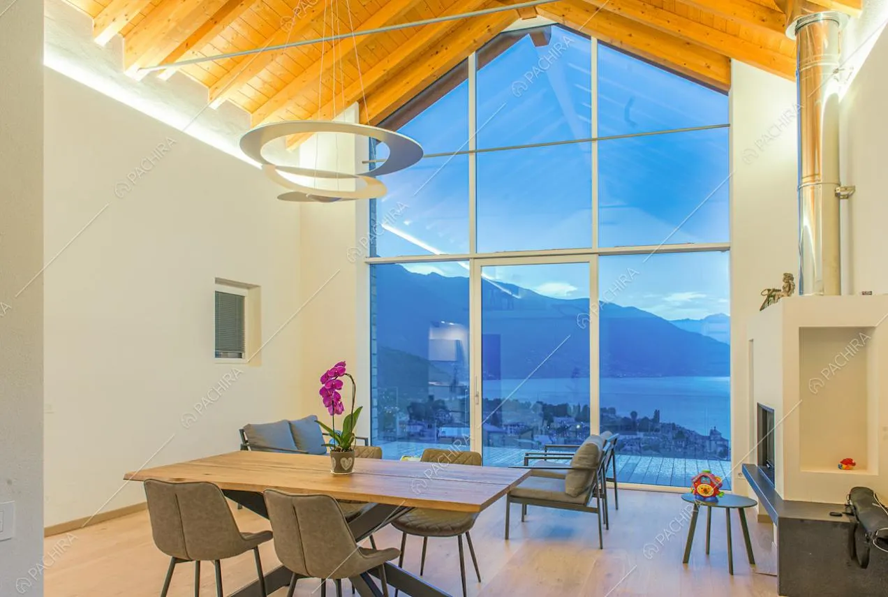 Soggiorno dalle pareti bianche, con soffitto in travi in legno a vista, camino e pavimento in parquet