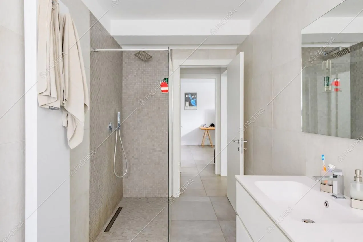 Box doccia nel luminoso bagno con pareti grigie