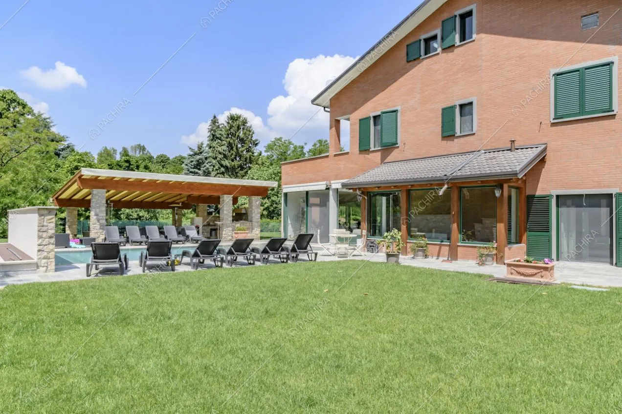 Curatissimo giardino della location con vista su piscina, su pergolato e veranda