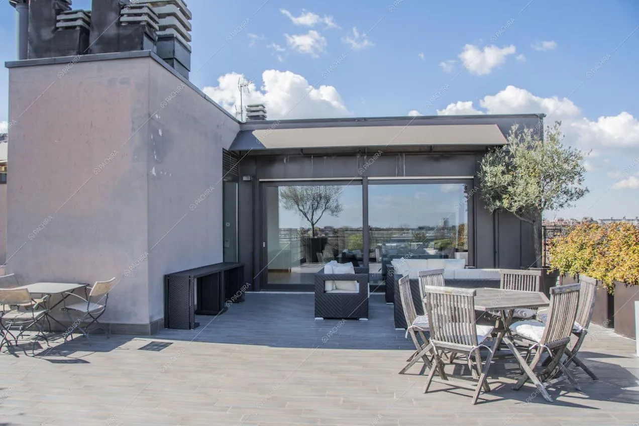 Terrazza con tavoli da pranzo e divano da esterno