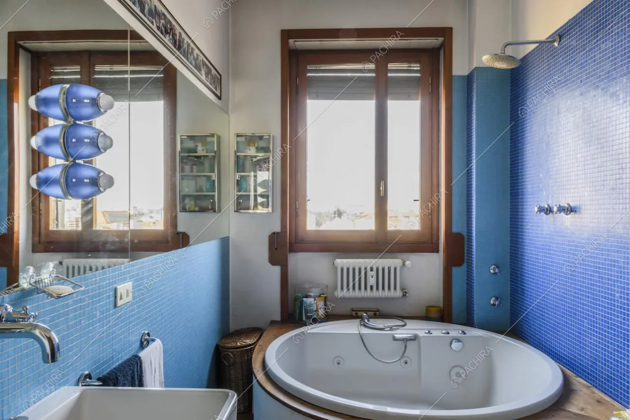 Vasca idromassaggio e pareti rivestite con piastrelline a mosaico blu