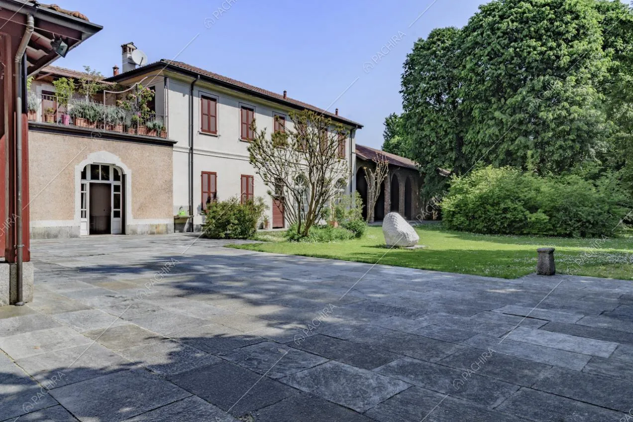 Esterni della dimora storica con vialetto in lastre di pietra e giardino privato