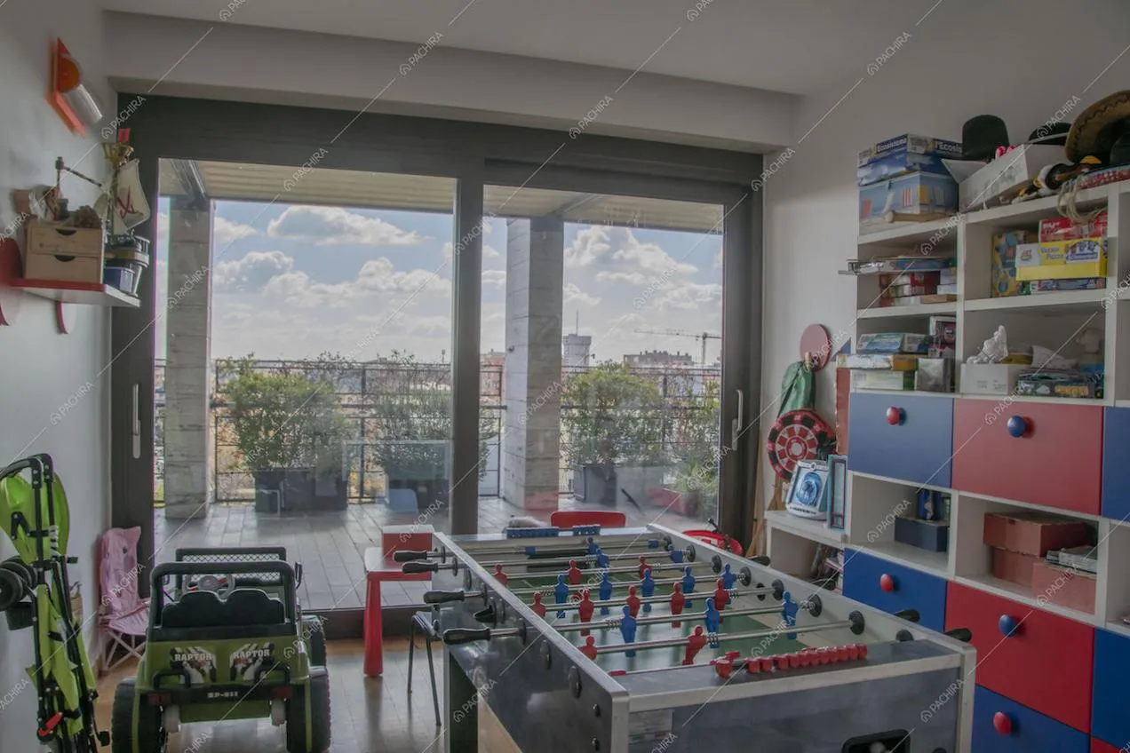 Stanza con giochi per bambini e biliardino con accesso alla terrazza da porta-finestra scorrevole