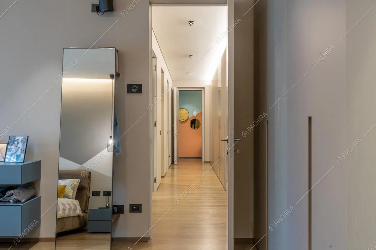 Dalla camera da letto matrimoniale vista sul corridoio con pavimento in parquet e sulla parete dello studio