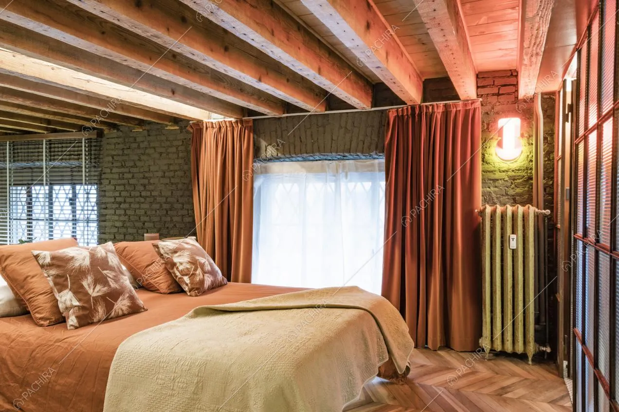 Camera matrimoniale con pavimento in parquet in noce a spina ungherese e grandi finestre