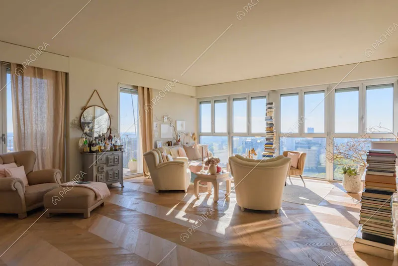 Pavimento in parquet a spina di pesce nel salotto con vista sullo skyline tramite le vetrate