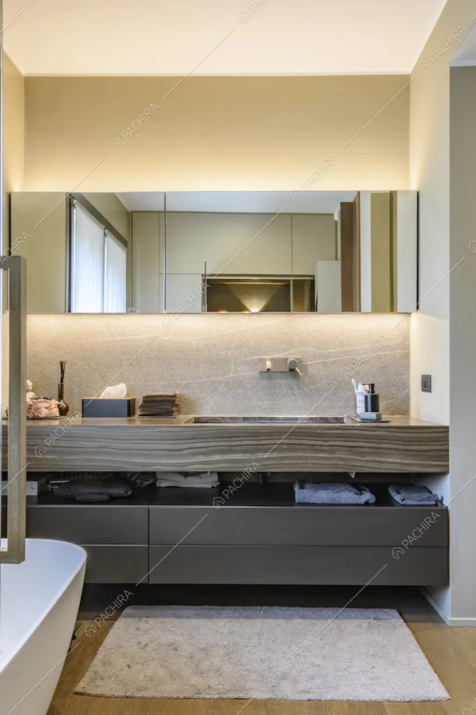 Bagno con arredi moderni e specchio orizzontale sopra al lavandino