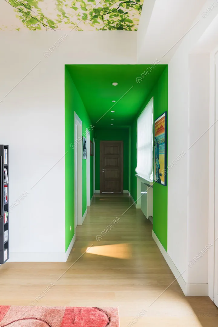 Vista sul lungo corridoio con pareti verdi e pavimento in parquet