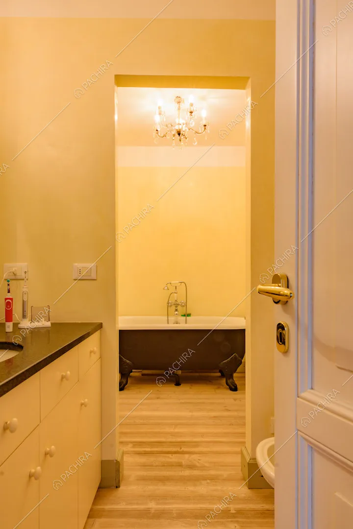 Vista sul bagno con vasca nera e pavimento in parquet