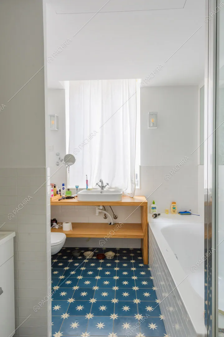 Luminoso bagno con vasca e pavimento in piastrelle blu con stelle