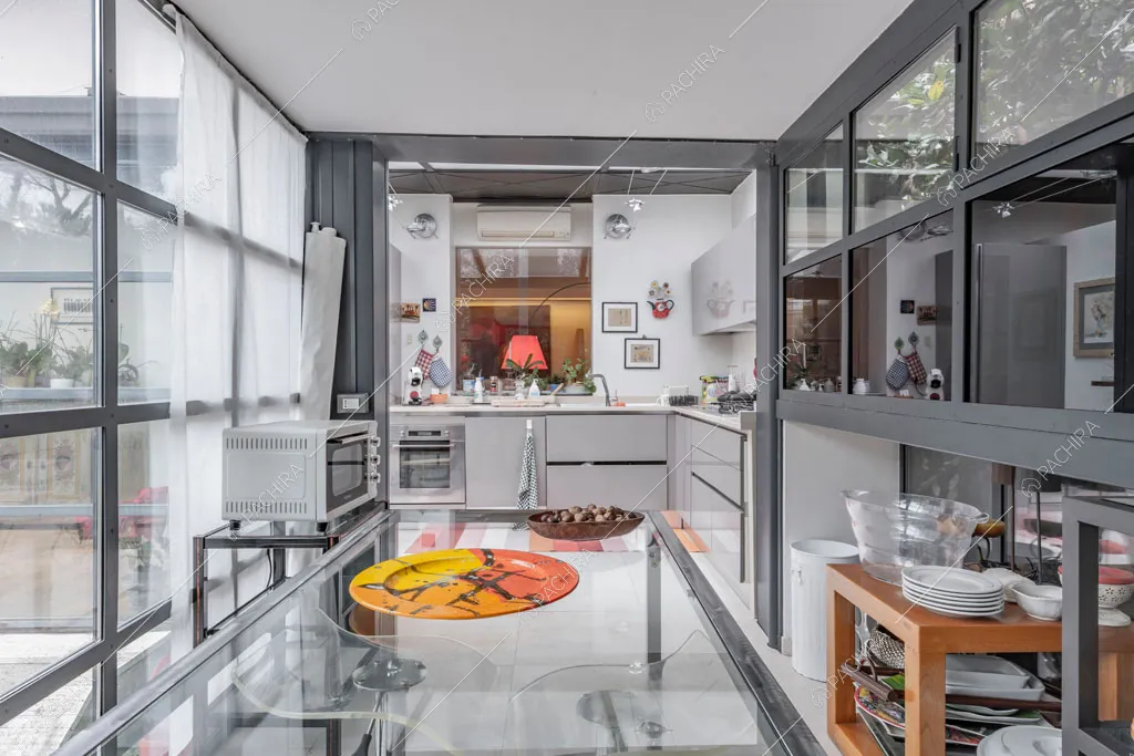 Cucina a parete con pareti vetrate dell'appartamento Catalpa, location in stile moderno a Roma