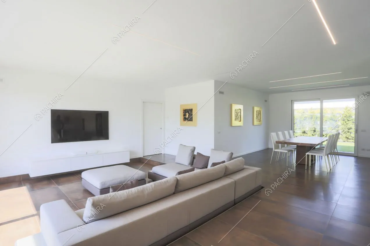 Sala con divano angolare con isola e sul tavolo da pranzo