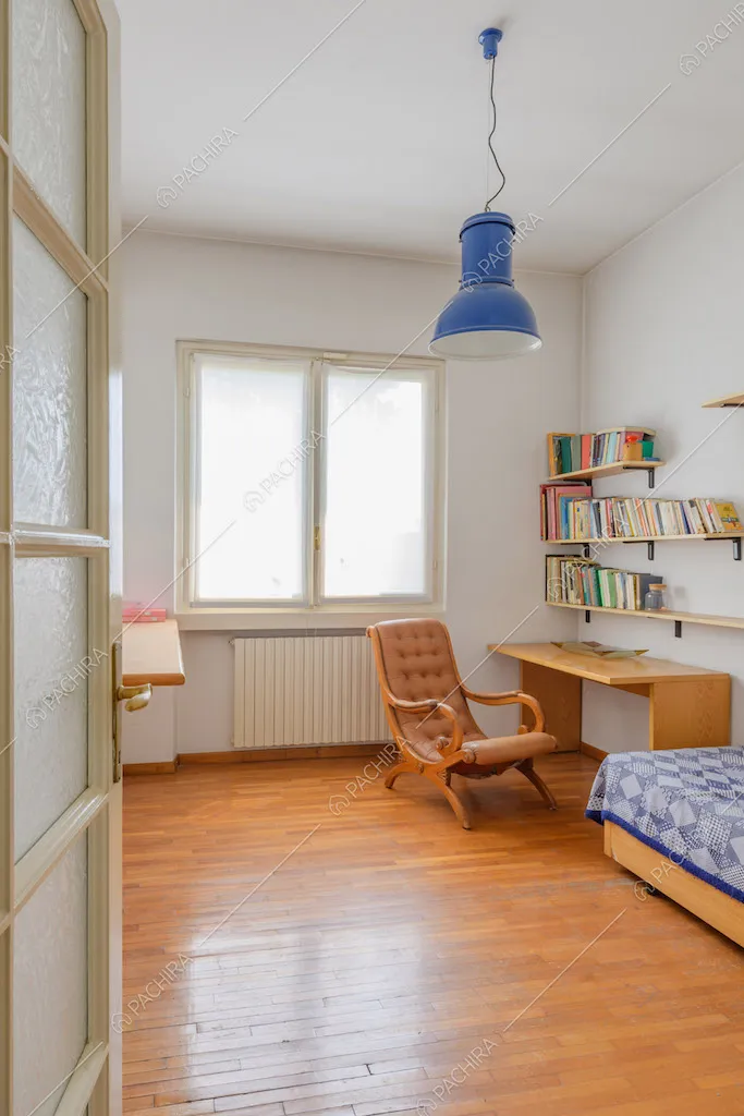 Camera da letto con pavimento in parquet e scrivania in legno