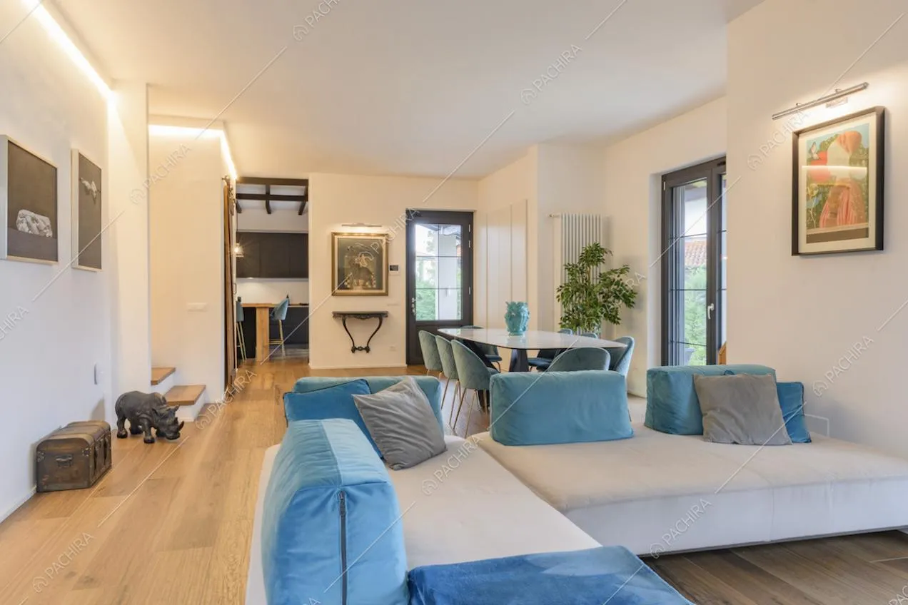 Divano ad angolo bianco con dettagli in velluto blu